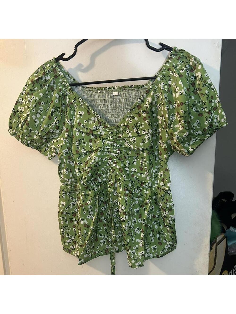 Green floral blouse with v-neck and tie back detail. Size: S